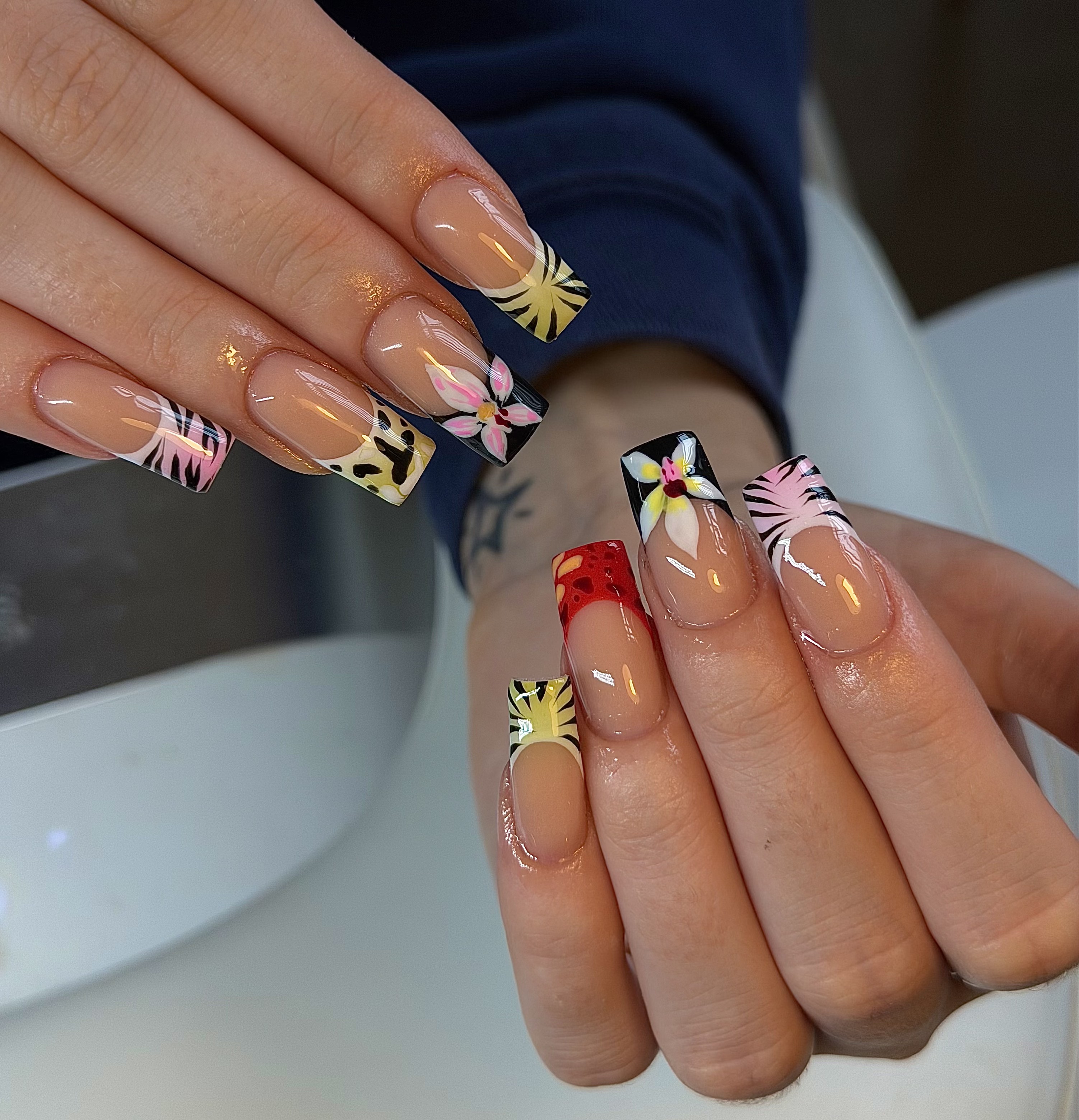 Colourful acrylic nail art with hand-painted patterns at SLX Studio